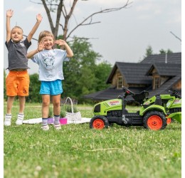Žalias pedalais minamas Claas traktorius su priekaba