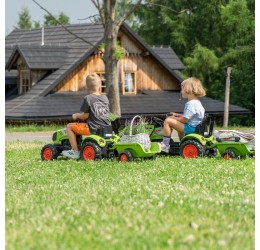 Žalias pedalais minamas Claas traktorius su priekaba