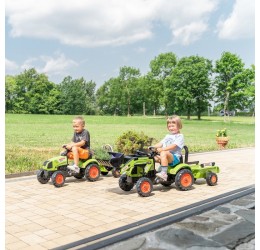 Žalias pedalais minamas Claas traktorius su priekaba