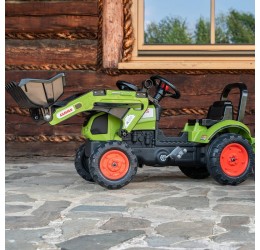 Žalias pedalais minamas Claas traktorius su priekaba