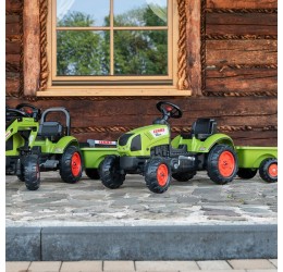 Žalias pedalais minamas Claas traktorius su priekaba